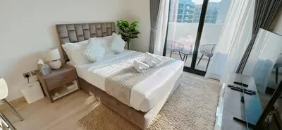a bedroom with a large bed and a balcony at Elegant Studio Apartment In Meydan One in Dubai