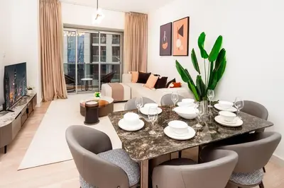 a living room with a table with chairs and a couch at Prime retreats - steps to Grosvenor Hotel in Dubai