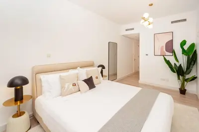 a bedroom with a white bed and a plant at Prime retreats - steps to Grosvenor Hotel in Dubai