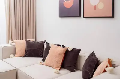 a white couch with a bunch of pillows on it at Prime retreats - steps to Grosvenor Hotel in Dubai