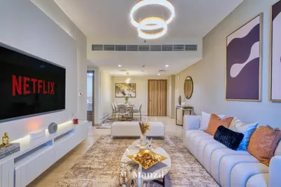a living room with a couch and a tv at 2BR Apt in Business Bay with Iconic Burj Khalifa and Dubai Canal Views in Dubai