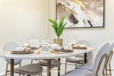 a white dining room table with chairs and a painting at 2BR Apt in Business Bay with Iconic Burj Khalifa and Dubai Canal Views in Dubai