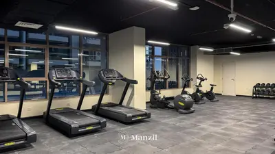 a gym with several treadmills and elliptical machines at 2BR Apt in Business Bay with Iconic Burj Khalifa and Dubai Canal Views in Dubai