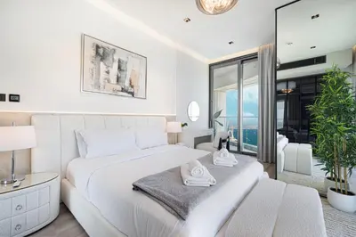 a white bedroom with a large bed and a window at Address JBR, Beach View, Jumeirah Beach Residence - Mint Stay in Dubai
