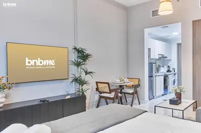 a living room with a flat screen tv on a wall at bnbmehomes - Serenity Lakes 5 in Dubai