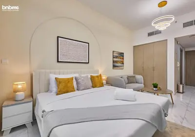 a bedroom with a large white bed and a chair at bnbmehomes - Serenity Lakes 5 in Dubai