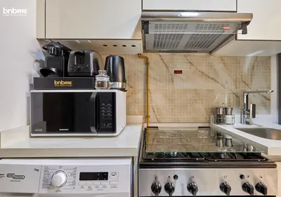 a kitchen with a microwave oven and a stove at bnbmehomes - Serenity Lakes 5 in Dubai