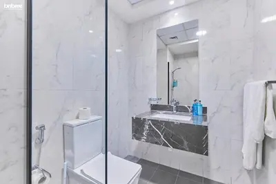 a bathroom with a shower and a toilet and a sink at bnbmehomes - Serenity Lakes 5 in Dubai