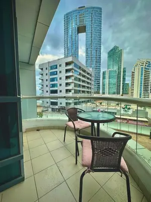 a balcony with a table and chairs and a view of a city at Marina Comfort Room with Bath inside in Dubai