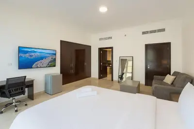 a bedroom with a bed and a desk and a couch at Marina Comfort Room with Bath inside in Dubai