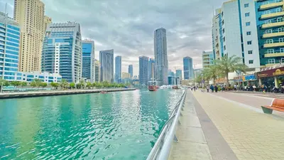 a river in the middle of a city with tall buildings at Marina Comfort Room with Bath inside in Dubai