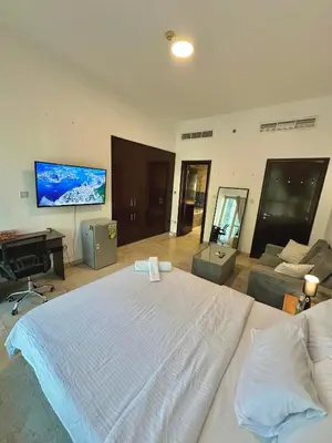a bedroom with a large bed and a flat screen tv at Marina Comfort Room with Bath inside in Dubai