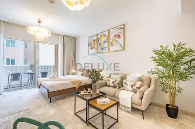 a living room with a couch and a table at Contemporary Studio in Manara 6, Jebel Ali by Deluxe Holiday Homes in Dubai