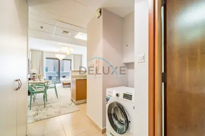 a kitchen and living room with a washing machine at Contemporary Studio in Manara 6, Jebel Ali by Deluxe Holiday Homes in Dubai