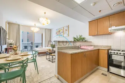a kitchen and living room with a table and chairs at Contemporary Studio in Manara 6, Jebel Ali by Deluxe Holiday Homes in Dubai