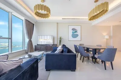 a living room with a blue couch and a table at GLOBALSTAY Palm View in Dubai