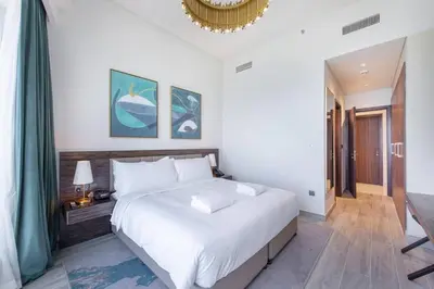 a bedroom with a large white bed and a chandelier at GLOBALSTAY Palm View in Dubai