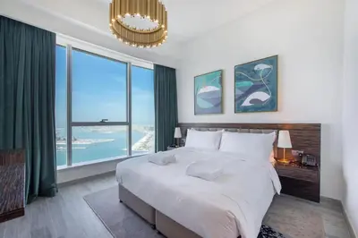 a bedroom with a large bed and a large window at GLOBALSTAY Palm View in Dubai
