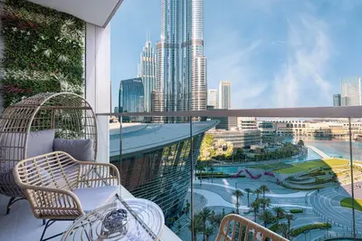 a balcony with chairs and a view of a city at Grande Signature by Emaar! Best Full Burj Khalifa, Fountains, Park View! in Dubai