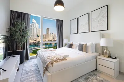 a bedroom with a large bed and a large window at Grande Signature by Emaar! Best Full Burj Khalifa, Fountains, Park View! in Dubai