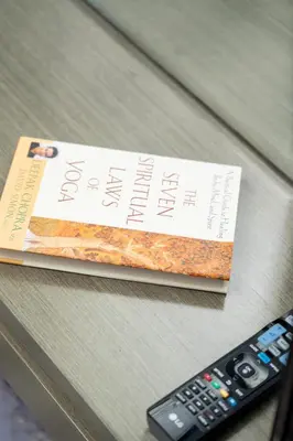 a book sitting on a table next to a remote control at DAMAC MAISON PRIVE - Lake View in Dubai