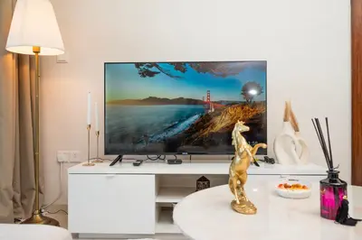 a living room with a television on a wall at Luxury Haven 2BR I Damac Vera I City Views in Dubai