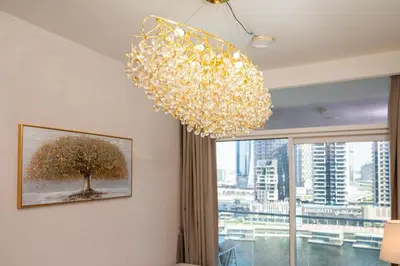 a chandelier in a room with a picture of a tree at Luxury Haven 2BR I Damac Vera I City Views in Dubai