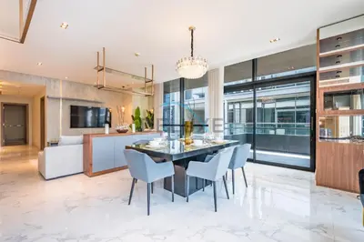 a dining room and kitchen with a dining table and chairs at Radiant 2BR with Assistant Room at Citywalk Residential Building 7, Al Wasl by Deluxe Holiday Homes in Dubai