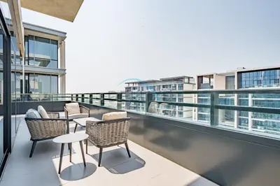 a balcony with chairs and tables on a building at Radiant 2BR with Assistant Room at Citywalk Residential Building 7, Al Wasl by Deluxe Holiday Homes in Dubai