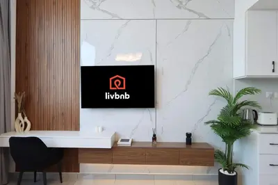 a desk in a kitchen with a tv on a wall at Modern Studio in JVC, Near Parks and Highways in Dubai