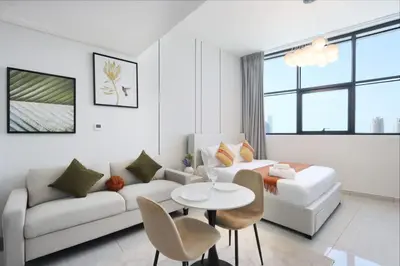 a living room with a white couch and a table at Modern Studio in JVC, Near Parks and Highways in Dubai