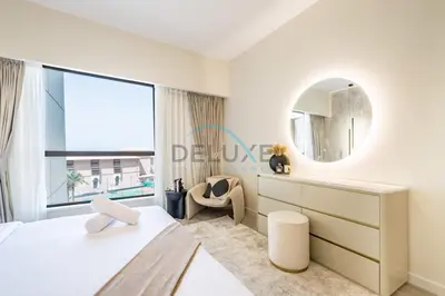 a white bedroom with a mirror and a chair at Luxurious 2BR Apartment at Sadaf 6, Jumeirah Beach Residence by Deluxe Holiday Homes in Dubai