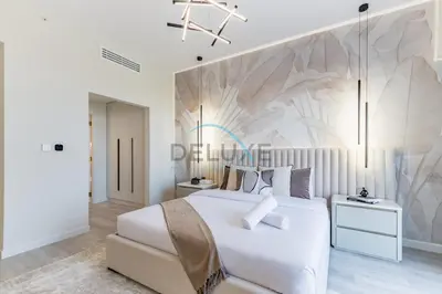 a bedroom with a large white bed and a wall at Luxurious 2BR Apartment at Sadaf 6, Jumeirah Beach Residence by Deluxe Holiday Homes in Dubai