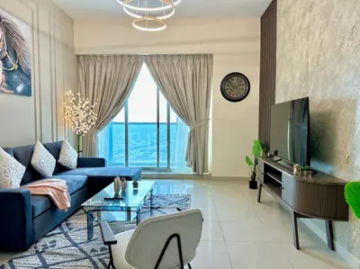 a living room with a blue couch and a tv at Renovu Exclusive Residences in Dubai in Dubai