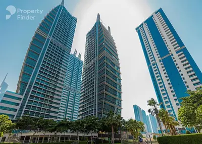 three tall buildings in a city with palm trees at Renovu Exclusive Residences in Dubai in Dubai