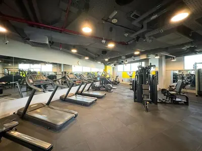 a gym with a row of treadms and machines at LUXE | 1BR | Heart of DIFC & Trade Centre in Dubai