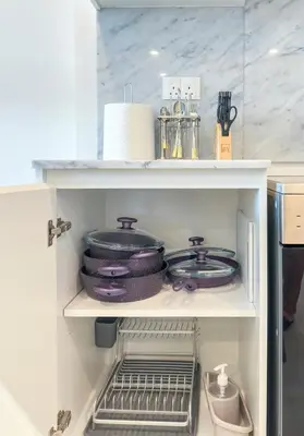 a shelf with pans and utensils in a refrigerator at Ultra Luxury Flat with Amazing Pool Near to Burj in Dubai