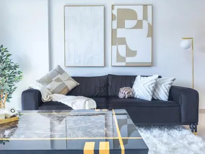 a living room with a black couch and a glass table at Ultra Luxury Flat with Amazing Pool Near to Burj in Dubai