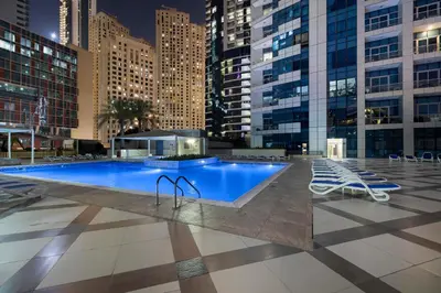 a pool in the middle of a city at night at Dubai Marina 3BR Penthouse with Stunning JBR, Marina & Dubai Eye Views in Dubai