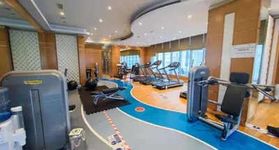 a gym with a bunch of treadmills and ellipticals at Whimsical 3BR at The Signature, Downtown Dubai by Deluxe Holiday Homes in Dubai