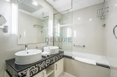 a white bathroom with two sinks and a mirror at Whimsical 3BR at The Signature, Downtown Dubai by Deluxe Holiday Homes in Dubai
