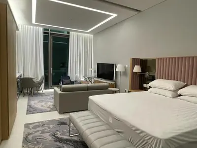 a bedroom with a large bed and a living room at Infinity luxury in Dubai