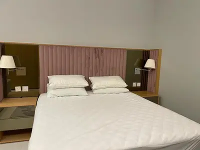 a large white bed with two pillows on it at Infinity luxury in Dubai