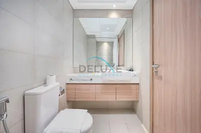 a bathroom with a toilet and a sink and a mirror at Cozy Studio in Azizi Riviera 44, Al Merkadh by Deluxe Holiday Homes in Dubai