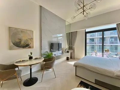 a bedroom with a bed and a table and a desk at Trendy Studio with top Amenities in Dubai