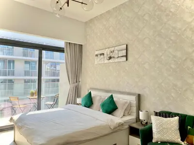 a bedroom with a bed and a large window at Trendy Studio with top Amenities in Dubai