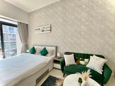 a bedroom with a bed and a green couch at Trendy Studio with top Amenities in Dubai