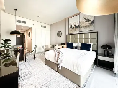 a bedroom with a large bed and a desk at Trophy Stays - Supreme Opulence - Chic Studio in Business Bay in Dubai