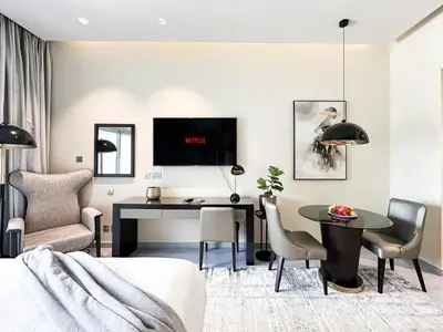 a living room with a table and a desk at Trophy Stays - Supreme Opulence - Chic Studio in Business Bay in Dubai