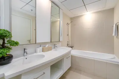 a white bathroom with a tub and a sink and a bath tubermott at Burj Khalifa Views - 5 min walk from Dubai Mall - Upgraded - Designer Choice - 8 people - Dubai Opera in Dubai
